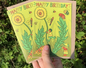 May include: Two green and yellow birthday cards with the text "Happy Birthday" on them. The cards feature a cartoon illustration of a dandelion with a person and a bug on it.