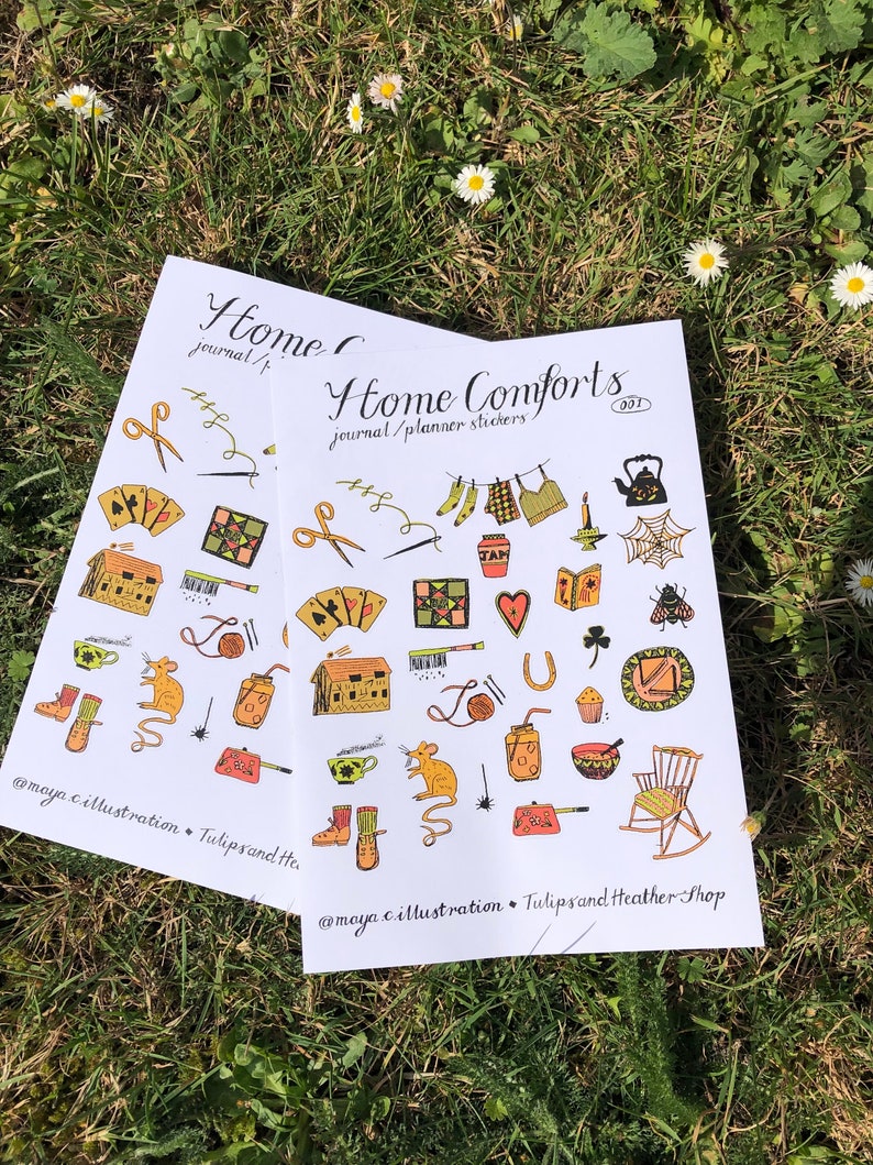 Puede incluir: Dos hojas de pegatinas con fondo blanco e ilustraciones coloridas. Las pegatinas son para diarios y planificadores. El texto en las pegatinas dice "Home Comforts" y "journal/planner stickers".