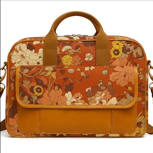 Peut inclure: Sacoche à motifs floraux avec une poignée supérieure et une bandoulière amovible. Le sac présente un fond orange chaud avec un motif floral répété dans des tons de jaune, crème et orange. La poignée et la poche avant sont marron uni.