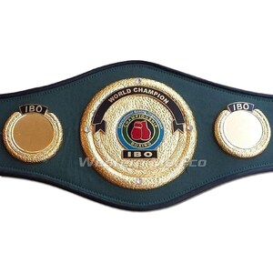 May include: A green and gold boxing championship belt with the words "World Champion" and "IBO" on it. The belt has two side plates with the letters "IBO" on them.