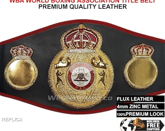 Könnte beinhalten: Replik eines schwarzen Leder-Boxweltmeister-Gürtels mit goldenen Akzenten. Der Gürtel verfügt über eine große Mittelplatte mit einer Krone, Boxhandschuhen und dem Schriftzug "World Boxing Association". Der Gürtel hat auch zwei kleinere Platten mit Kronen auf beiden Seiten.