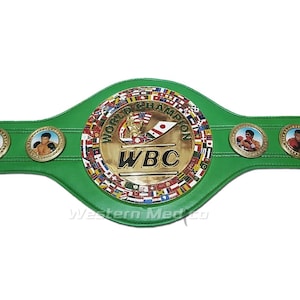 May include: Green leather boxing championship belt with gold accents. The belt features a large circular center plate with the words "World Boxing Council" and "WBC" in gold lettering. The center plate is surrounded by a ring of flags representing different countries.