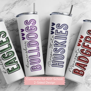 May include: Four white insulated tumblers with black straws. Each tumbler features a school name and mascot in bold colors: green Eagles, purple Bulldogs, blue Huskies, and red Badgers. The text "Customize for ANY School" is also visible.