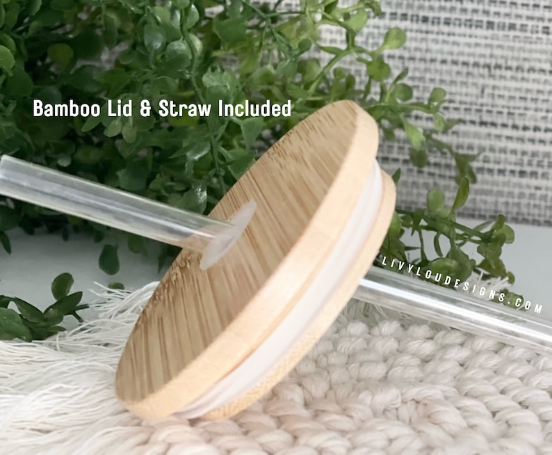 May include: A close-up of a bamboo lid and clear straw. The lid is light brown with a white rim and a hole for the straw. The text "Bamboo Lid & Straw Included" is visible in the image.