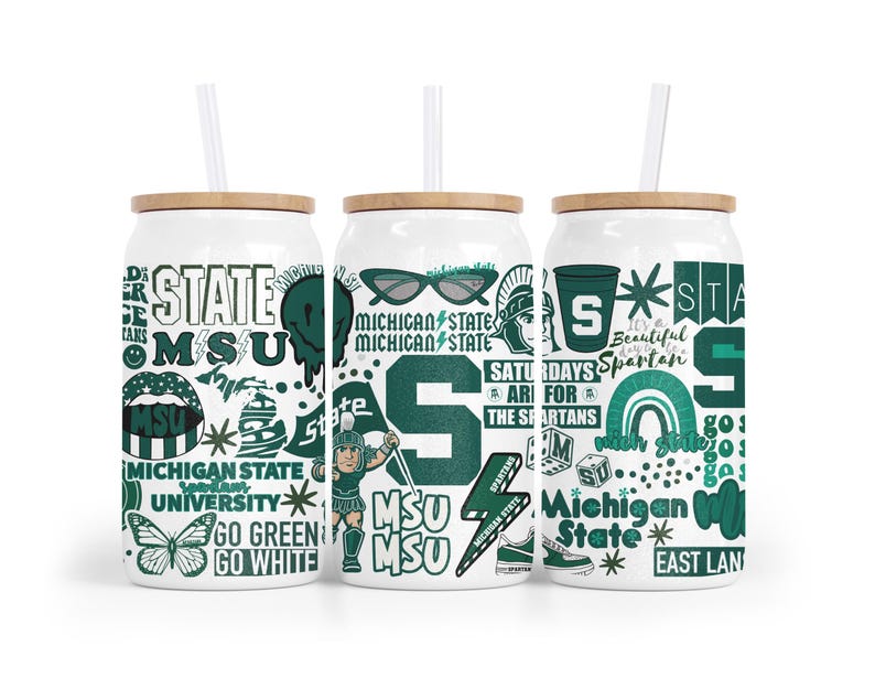 May include: Three white glass tumblers with bamboo lids and straws. Each tumbler has a different design with green and white graphics, including the text "MSU", "Michigan State", and Spartan-themed illustrations. The tumblers are designed for cold drinks.