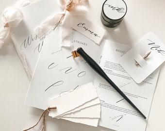 May include: A calligraphy kit with a black calligraphy pen, ink pot, and a set of blank cards with the word "Emma" written on one of them. The kit also includes a guide with instructions on basic calligraphy strokes.