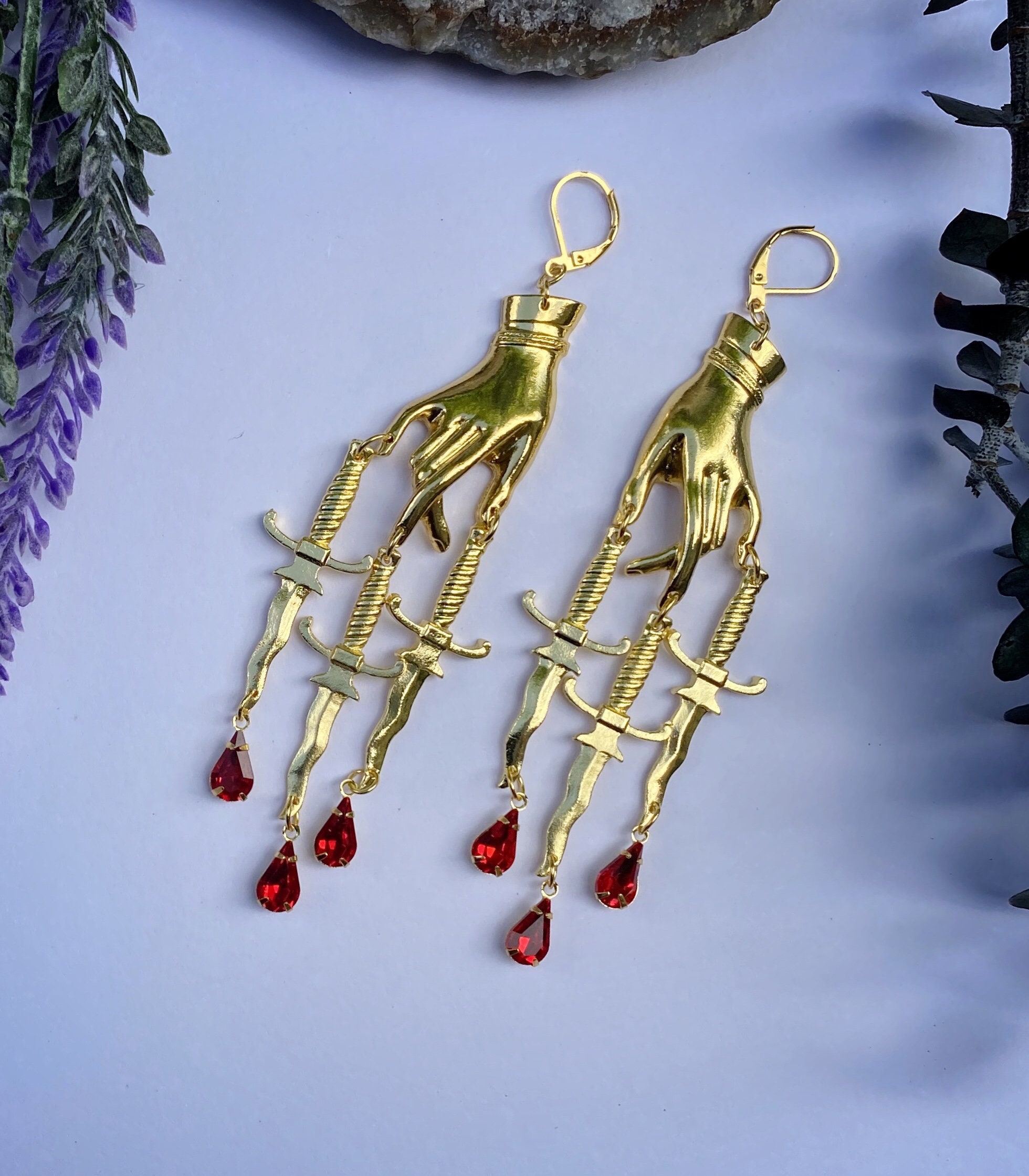 Gold toned Hand and Triple Sword Dagger Dangle Earrings with Red Bloo…