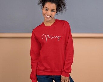 May include: A red sweatshirt with the word "Merry" in white cursive lettering on the front.