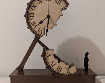 May include: A brown wooden clock sculpture with a surreal design. The clock face is partially broken, with Roman numerals. A small figure in a top hat stands near the base. The clock measures approximately 12 inches tall.