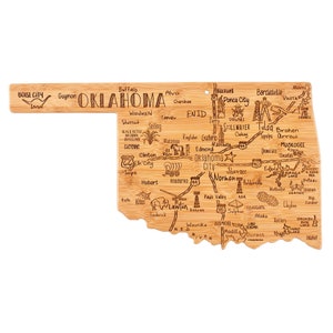May include: A wooden cutting board shaped like the state of Oklahoma with the names of cities and towns engraved on it. The board is brown and has a natural wood grain.
