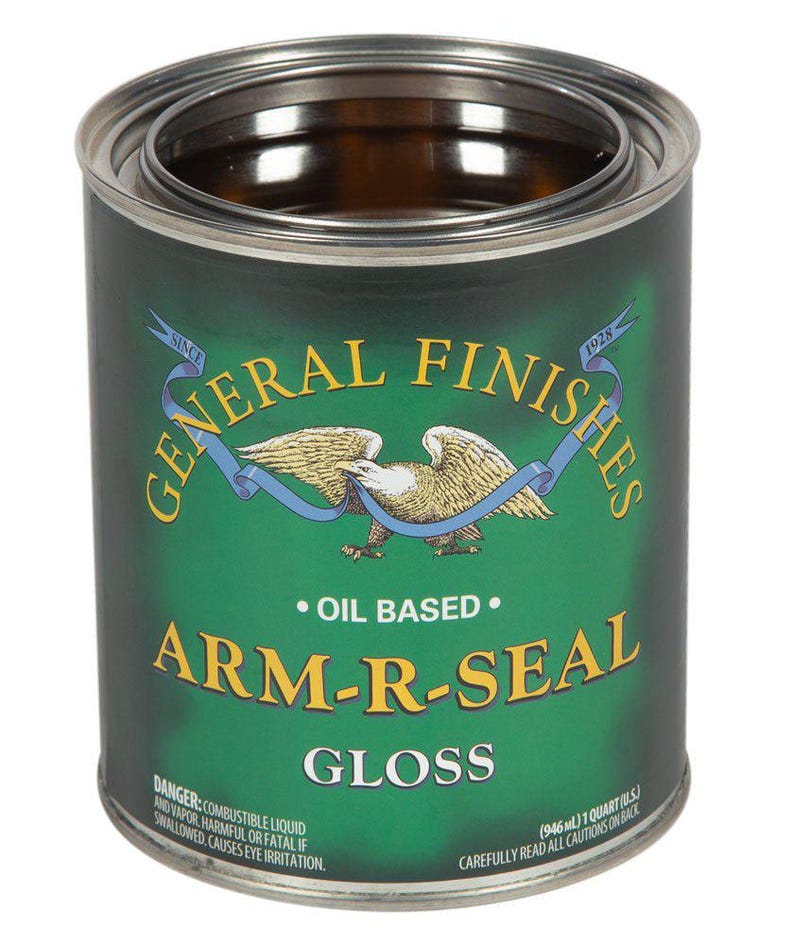 May include: A green can of General Finishes Arm-R-Seal Gloss oil-based wood finish. The can has a red, white, and blue eagle logo with the words "Since 1928" on the label. The can is 1 quart (946 ml).