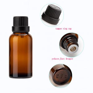 May include: Amber glass bottle with a black cap, designed for essential oils or similar products. The image includes close-ups of the cap and dropper, with text indicating a 30ml capacity. The bottle is a dark brown color.