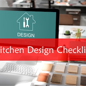 May include: A computer screen displaying a home design icon with the word "DESIGN" and the text "Kitchen Design Checklist" in red on a white background. A keyboard and a sample of wood flooring are visible on the desk.