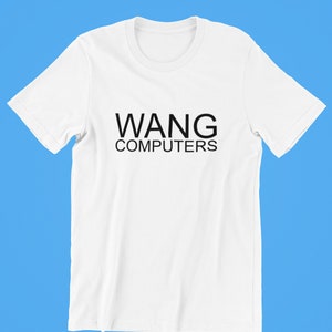 以下が含まれることがあります： 黒い文字で「WANG COMPUTERS」と書かれた白いTシャツ