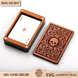 May include: A rectangular wooden playing card box with a dark brown finish. One part holds a deck of cards with an ace of diamonds visible, while the other part is a lid featuring an intricate laser-cut floral pattern surrounding a central skull.