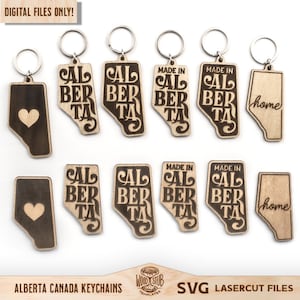 May include: Ten laser cut wooden keychains featuring the outline of the province of Alberta, Canada. Some keychains feature the text "Made in Alberta" and others feature the word "home".