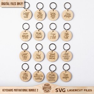 May include: A set of 16 laser cut wooden keychains with motivational quotes. The keychains are round and feature a variety of inspirational messages, such as "Good Vibes Only", "Dream Believe Achieve", and "Make Today Magical".