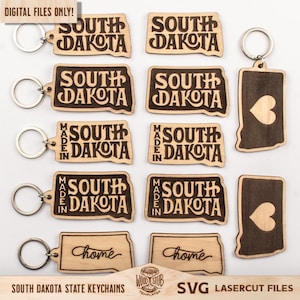 May include: Wooden keychains in the shape of South Dakota, some with "South Dakota" and "Made in South Dakota" engraved. Other keychains have a heart shape. The keychains have silver key rings.