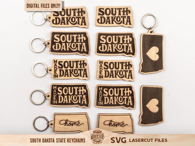 May include: Wooden keychains in the shape of South Dakota, some with "South Dakota" and "Made in South Dakota" engraved. Other keychains have a heart shape. The keychains have silver key rings.