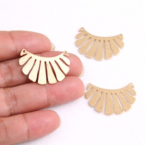 May include: Three gold metal fan-shaped embellishments with a textured surface and two holes at the top.