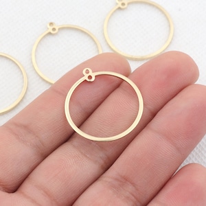 May include: Four gold-colored metal hoops with a small loop at the top. The hoops are different sizes and are on a white surface.