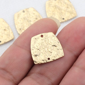 May include: Gold-toned metal square-shaped charms with a textured surface and two holes. The charms are approximately 1 inch in size.