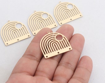 May include: Gold-colored metal charm pendants with a rainbow design. Each pendant has a half-circle shape with a circular cutout and multiple holes for attaching to jewelry. The pendants are shown in a hand.