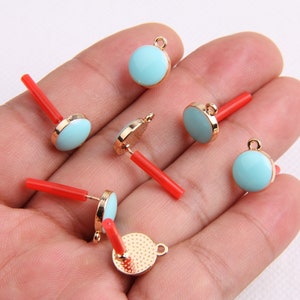 Puede incluir: Seis hallazgos de pendientes de tono dorado con cabujones redondos de color azul claro y postes rojos.