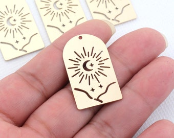 May include: Gold-toned metal charm with a crescent moon and sun design. The charm features a stylized sun with rays and a crescent moon with a star inside. There are also three small stars in the bottom of the charm.