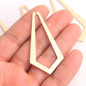May include: Gold-toned metal earring blanks with a geometric, diamond-shaped design. The blanks have a textured surface and a hole at the top for attaching earring wires.
