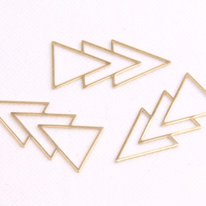May include: Set of six gold-toned metal triangle shapes. The triangles are layered and overlapping, creating a geometric design.