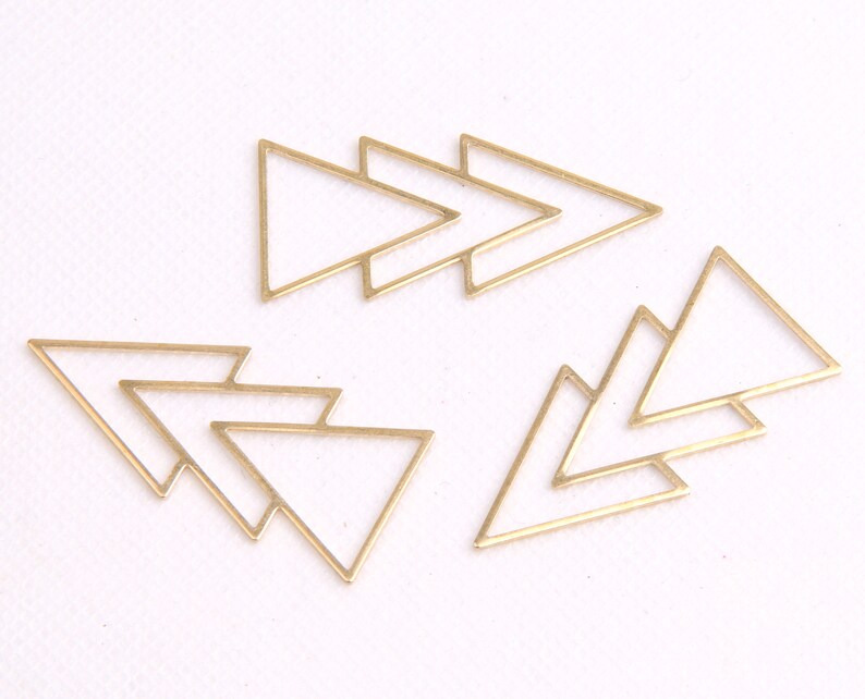 May include: Set of six gold-toned metal triangle shapes. The triangles are layered and overlapping, creating a geometric design.