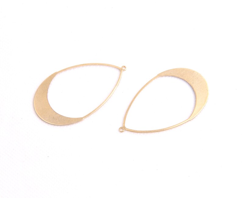 May include: Two gold-toned metal teardrop-shaped earring blanks with a rounded top and a jump ring.