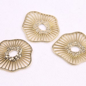 May include: Three gold-colored metal decorative pieces with a sunburst design and a textured center hole.