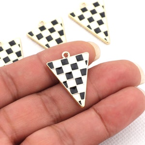 May include: Four gold-tone triangle-shaped charms with a black and white checkered pattern. The charms have a loop at the top for attaching to jewelry.