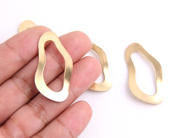 May include: Four gold-colored metal earring hoops with an irregular, organic shape.