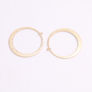 May include: A pair of gold-toned hoop earrings with a brushed finish. The earrings are simple and elegant, and would make a great addition to any jewelry collection.