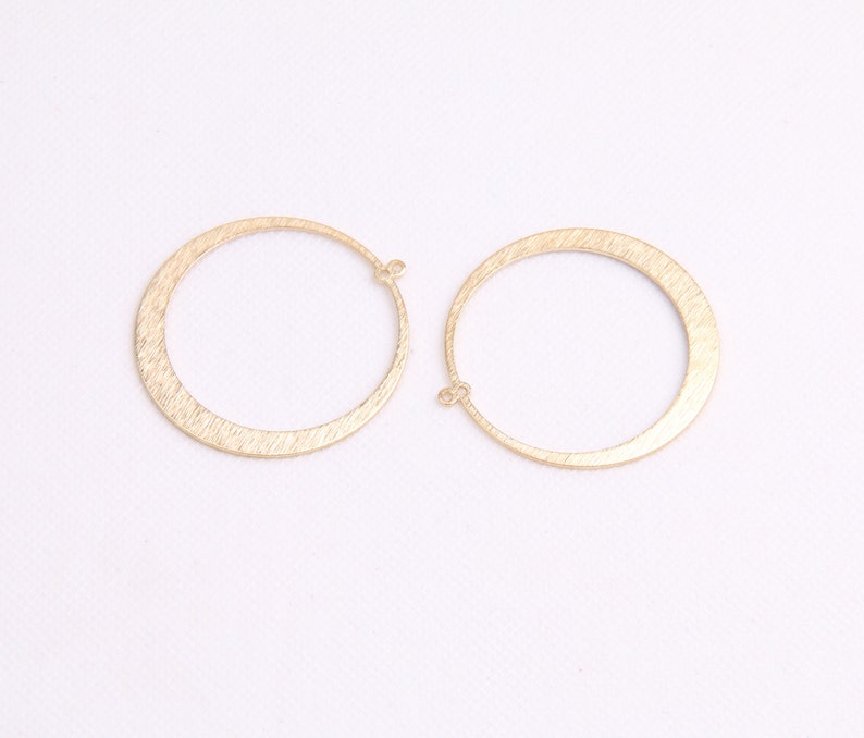 May include: A pair of gold-toned hoop earrings with a brushed finish. The earrings are simple and elegant, and would make a great addition to any jewelry collection.