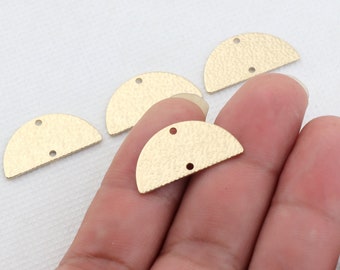 May include: Four gold-colored metal half-circle shapes with two holes each. The half-circles are textured and have a slightly rough surface.