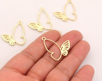 May include: Four gold-colored metal butterfly charms with a cutout design. The charms have a loop at the top for attaching to jewelry or other crafts.