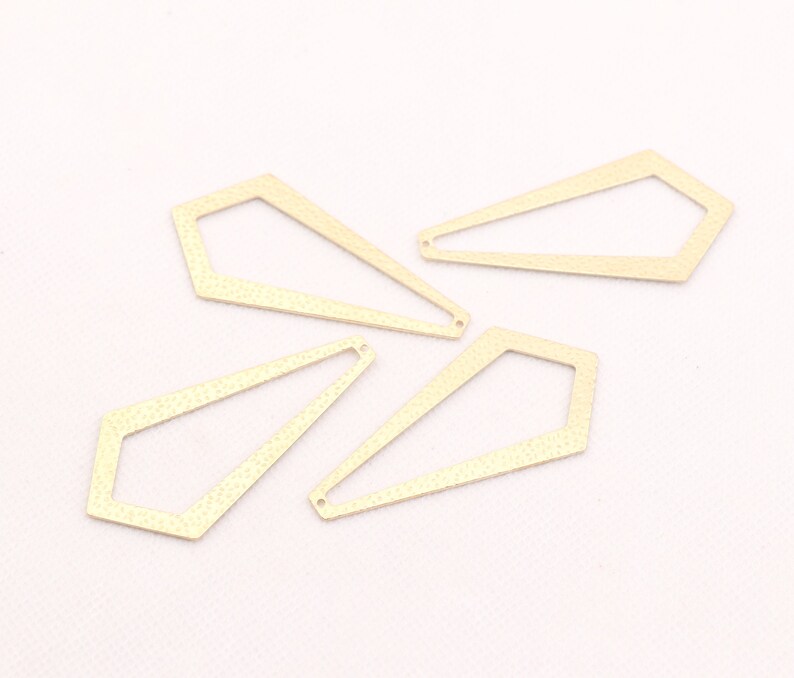 May include: Four gold-colored metal geometric shapes with a textured surface. The shapes are all similar in size and shape, but have slightly different angles. They are all open on one side.