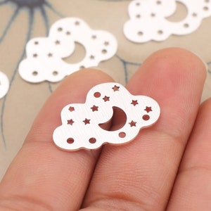 May include: Silver metal charms shaped like clouds with a crescent moon and stars cut out.