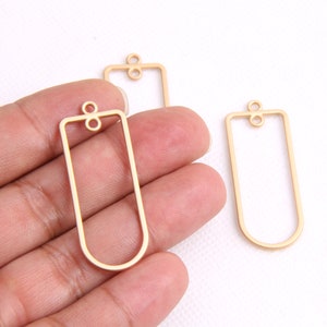 Könnte beinhalten: Drei goldfarbene rechteckige Metallrahmen mit einer Öse oben zum Aufhängen. Die Rahmen sind an allen Seiten offen.