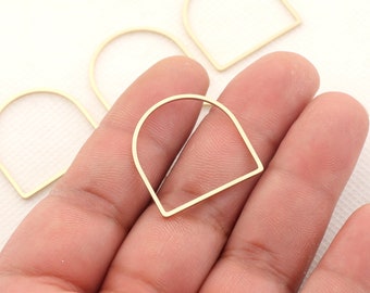 May include: A set of four gold-colored metal hoops in the shape of a teardrop. The hoops are shown in a hand, with the largest hoop in the foreground.