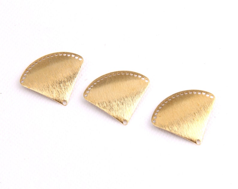 May include: Three gold-colored metal fan-shaped charms with a textured surface and a hole at the bottom.