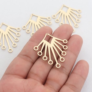 May include: Four gold metal earring blanks with a fan-shaped design. Each blank has a hole at the top for attaching a hook or other earring finding.