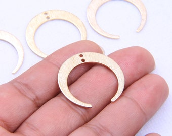 May include: Four gold-toned metal crescent moon shapes with two small holes in each. The crescent moons are approximately 1 inch in diameter.