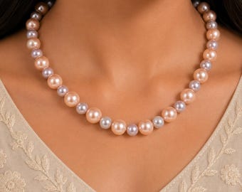 May include: A single-strand necklace featuring alternating round beads in soft peach and light lavender hues. The beads are uniform in size and arranged in a repeating pattern around the entire length of the necklace, resting against the collarbone.