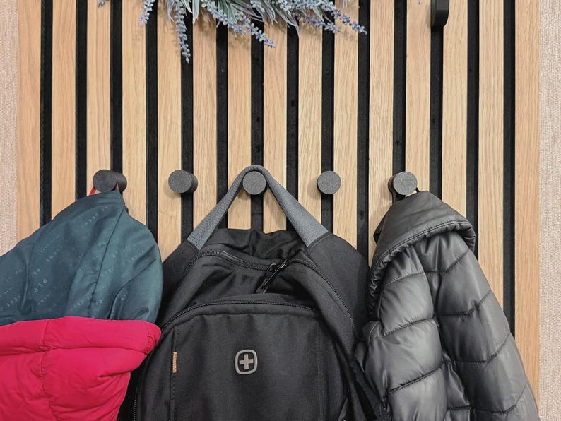 Knob coat hook for acoustic panels, black matte finish, no-drill and no-screw installation, perfect for organizing coats, bags, and accessories.