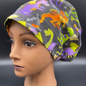 Può includere: Un berretto da lavoro nero con una stampa colorata di draghi e cappelli da strega. Il berretto è realizzato in tessuto morbido e confortevole ed è perfetto per infermieri, medici e altri professionisti sanitari.